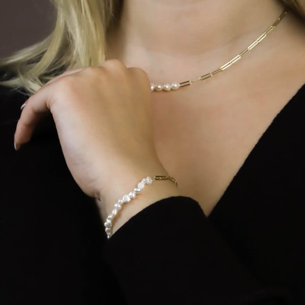 Naszyjnik z naturalnych pereł na szyi modelki i bransoletka na nadgarstku